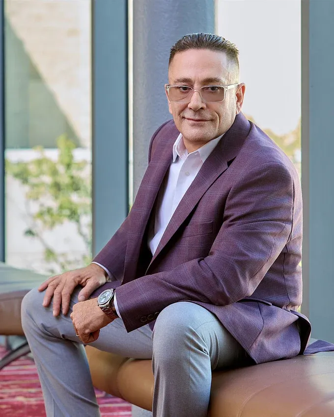 Russell Pastorino seated in a purple jacket